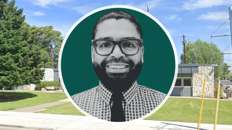 Adolph Muller, candidate for Sunnyside City Council, smiling in front of Sunnyside City Hall.